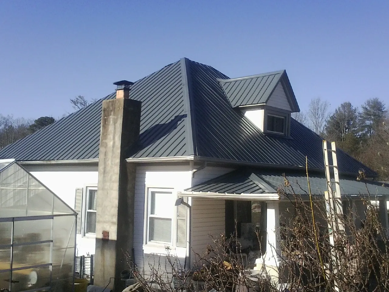 Dark blue standing seam metal roof on a white farmhouse with dormer — Slate & Tile Roof Repair by Roofing Brothers in Salisbury Mills