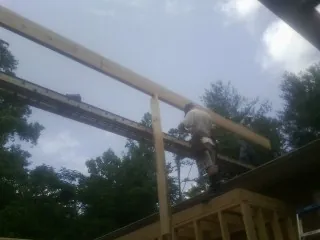 Carpenter setting a ridge beam over a new addition frame — Ice Dam Removal by Roofing Brothers in Salisbury Mills