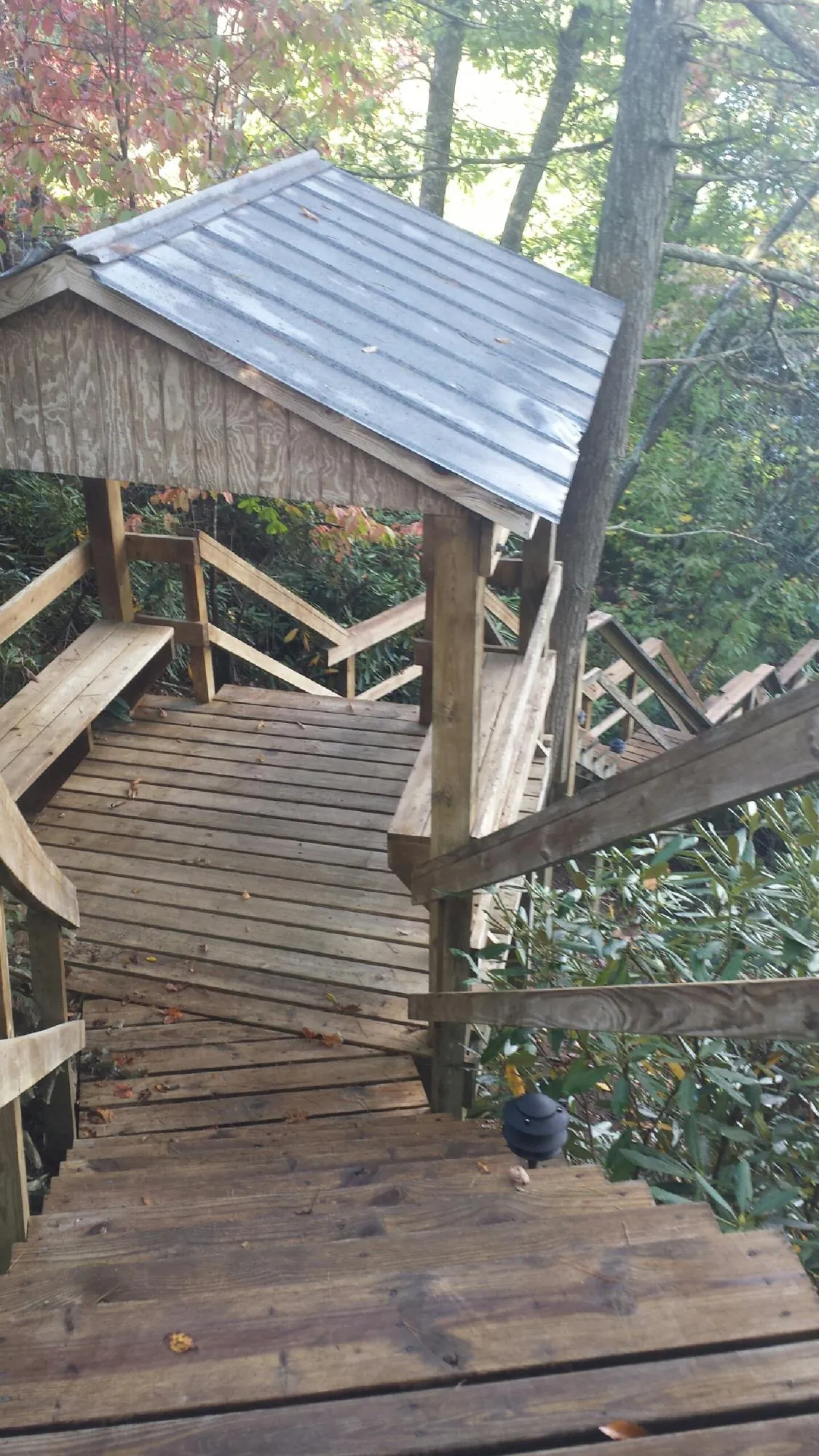 Metal roofed shelter over wooden steps on a wooded walkway — Skylight Repair & Installation work by our crew in Salisbury Mills
