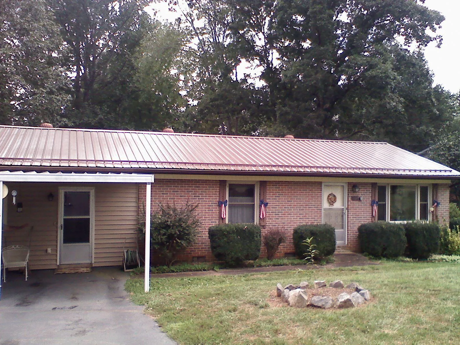 Bronze metal roof and carport on a brick ranch home — Roof Repair work by our crew in Salisbury Mills